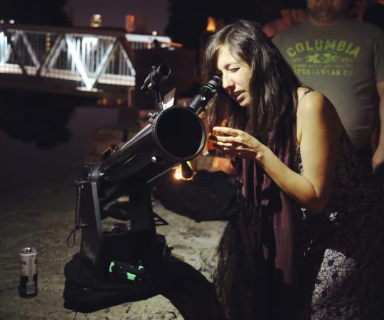 Person looking at the Moon with a telescope