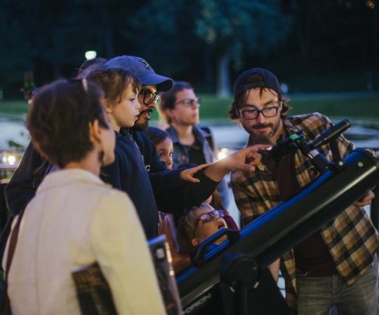 Trevor montrant aux invités la Lune avec un télescope